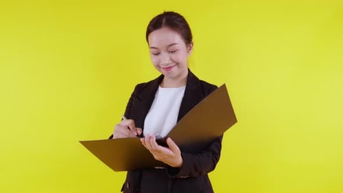 Portrait young asian businesswoman hold folder and writing record document with success.