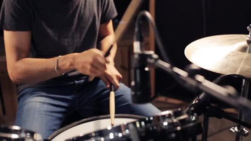 Music, People, Musical Instruments and Entertainment Concept - Male Musician with Drumsticks