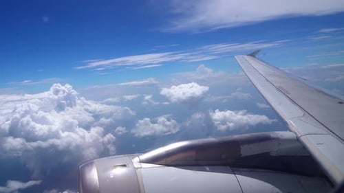 Plan de magnifiques nuages duveteux et de l'aile d'un avion visible depuis la fenêtre, avec la vue sur le ciel bleu