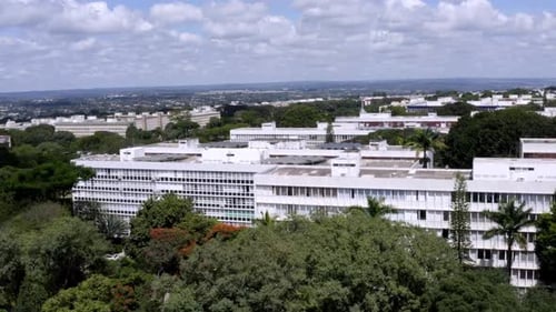 Aerial View of Modern White Buildings Nestled Within Lush Greenery