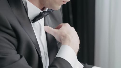 Close Up of a Man Dressed in Black and White Suit with a Bow Tie