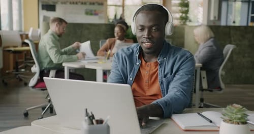 Young Adult Man Working on Laptop in Office