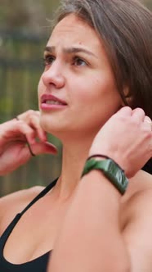 Woman tying her hair back after workout outdoors
