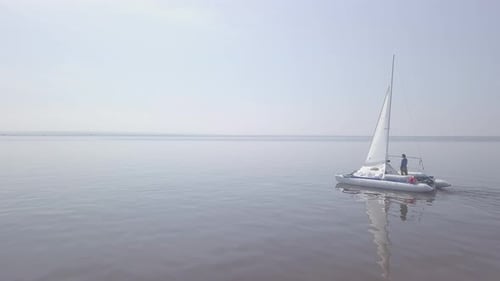 Sailboat Gliding on Calm Waters from Aerial View