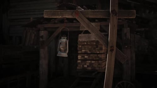 Vintage Oil Lamp Swinging in Dark Rustic Environment