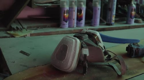 Respirator mask, tape measure, paint, other DIY workshop equipment on work bench