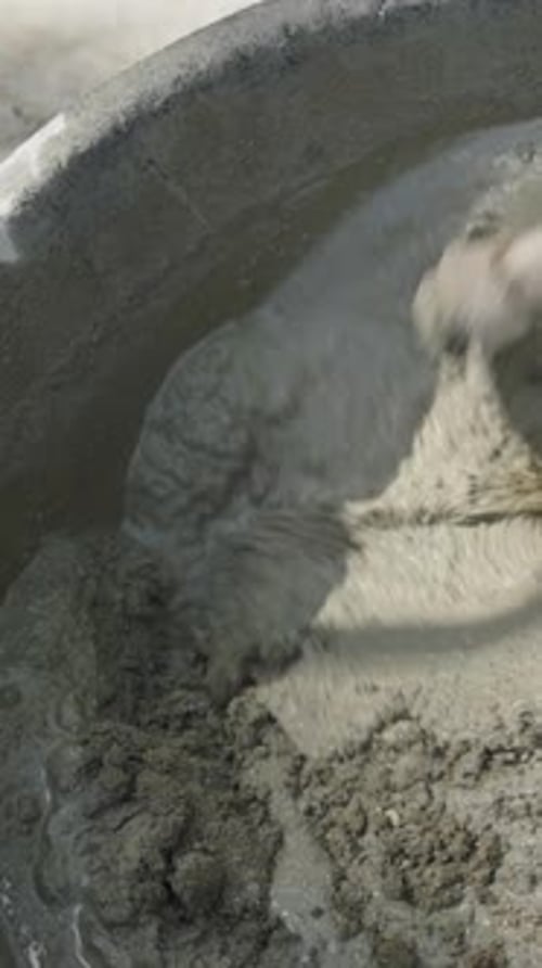 Mixing Wet Cement with a Wooden Tool