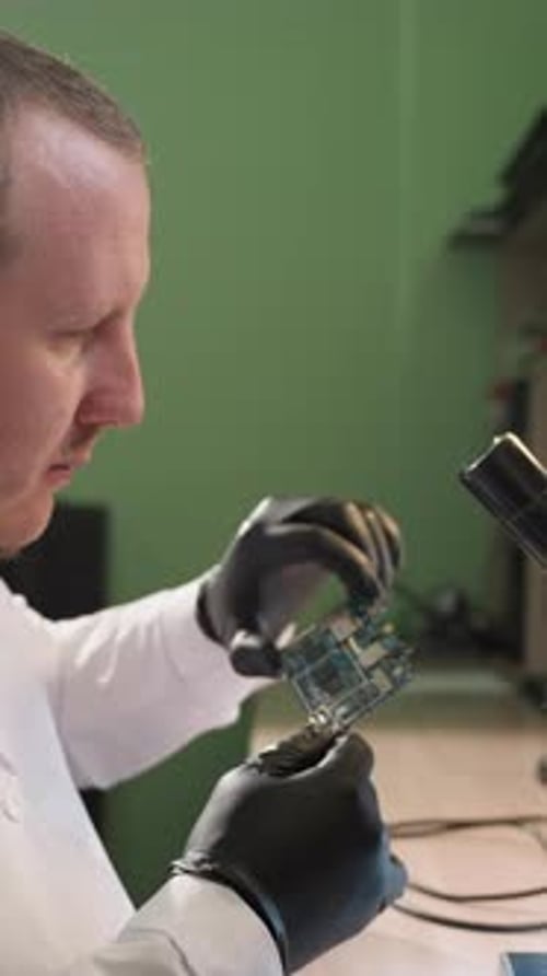 Techniker untersucht Leiterplatte unter dem Mikroskop im WellLit-Elektroniklabor