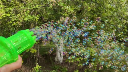 Little Girl Blowing Soap Bubbles Cute Child Playing in Park Outdoors with Toy Spray Gun Have Fun
