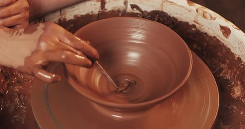 Potter in the Potter's Wheel Makes Ceramic Product Using His Hands and Pottery Tools Close Up