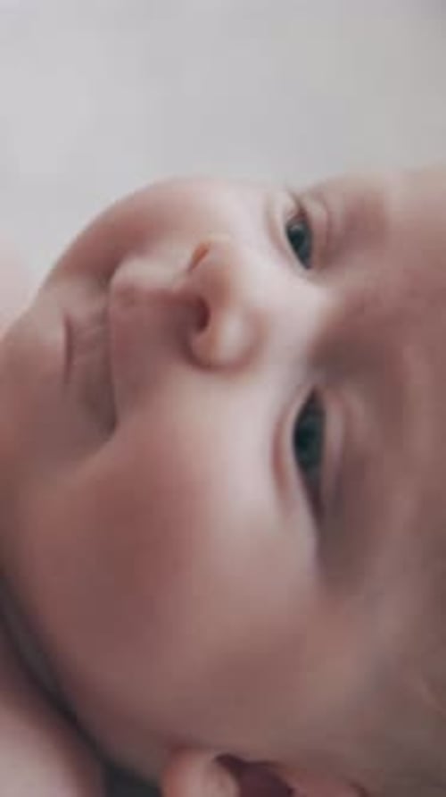 Joli petit garçon aux yeux bleus brillants est allongé sur une table à langer