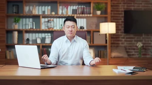 Relaxed Man Meditating at Office Desk