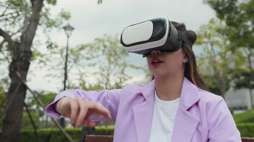 Excited Woman Using VR Goggles Playing Video Game in Park
