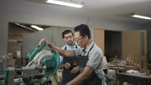 Carpenters are working together at workshop.