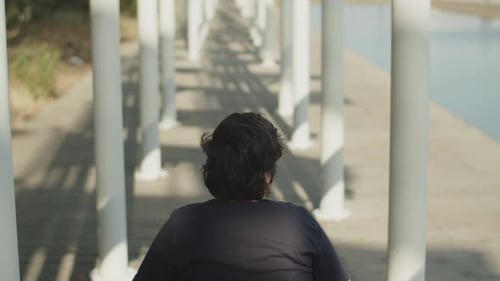 Rear View of Woman Using Wheelchair Walking Down Street