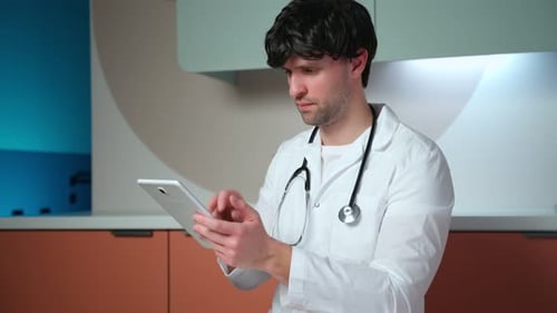 Male Doctor Using a Digital Tablet in a Clinic