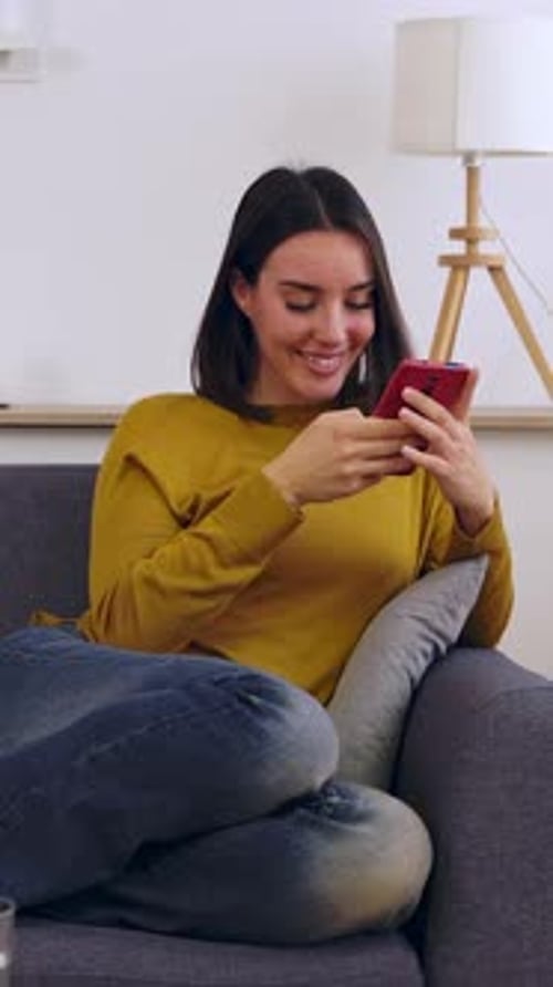 Woman Relaxing on Couch Using Mobile Device