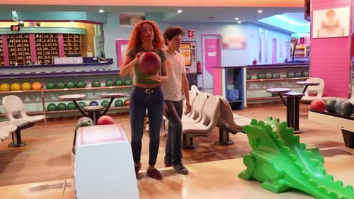 Young Woman Bowling with Friends in Slow Motion