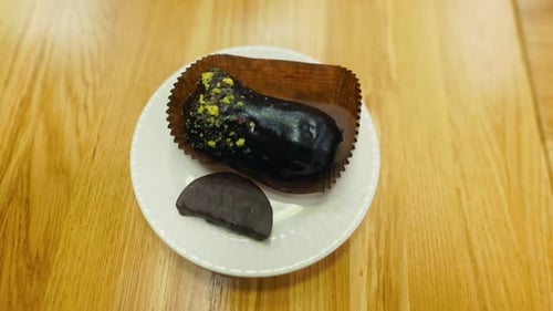 Wooden Table Displaying Two Chocolate Desserts on a White Plate