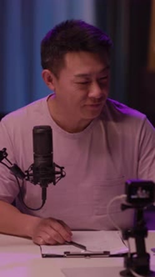 Un homme concentré travaille sur un ordinateur portable et un microphone dans un espace productif