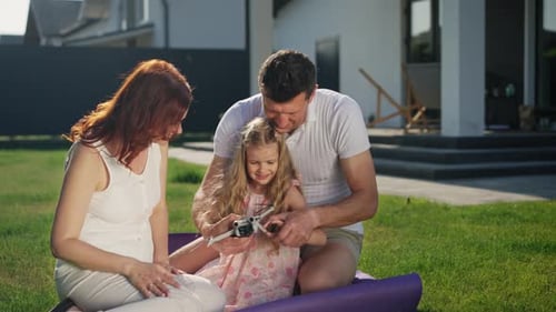 Happy Family Plays With Drone Toy on Lawn