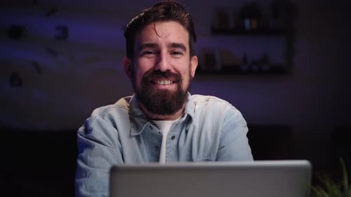 Man Smiling in Front of a Laptop