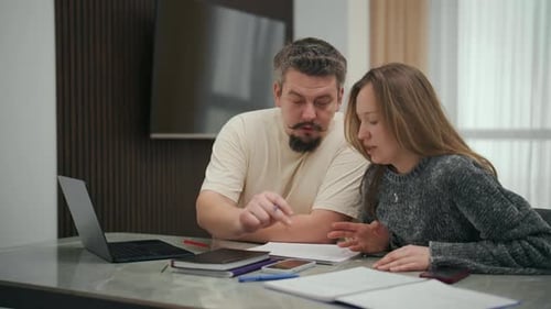 Man and Woman Discussing Documents Indoors