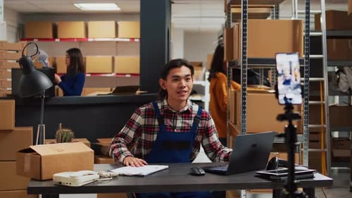 Young Adult Speaking to Phone Camera in Warehouse