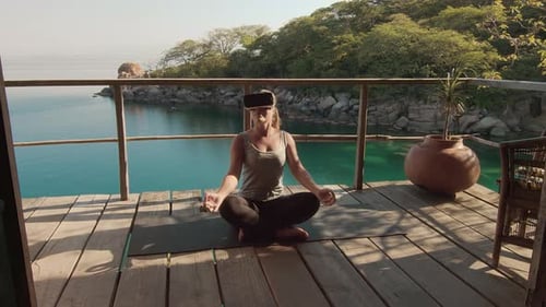 Woman Practices Meditation with VR Headset near Tropical Water