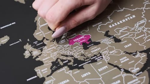 Female Hand Scratching the Surface of a Scratch Map with Poland Country