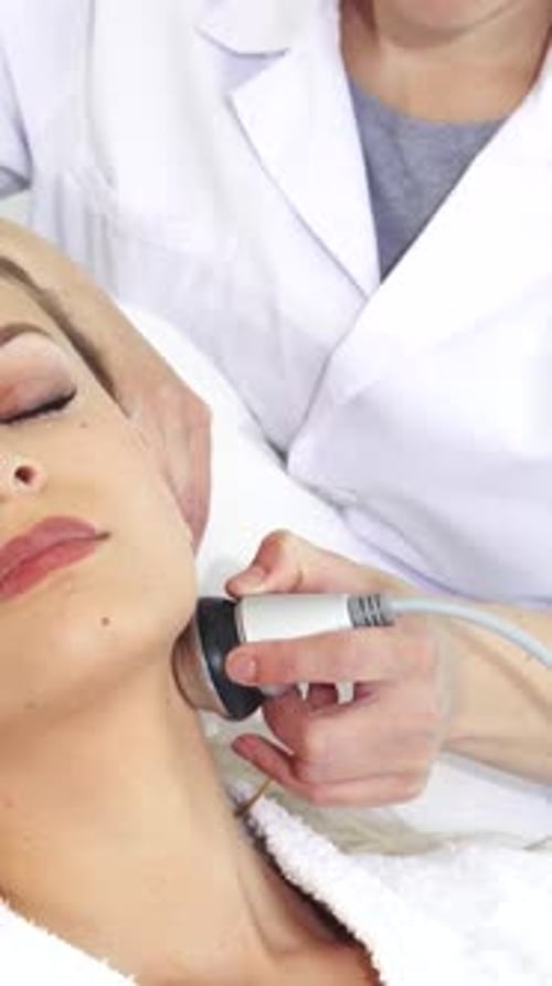 Woman Receiving Professional Facial Treatment in Clinic