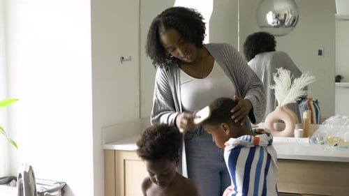 Woman Brushing Hair of Young Child in Bathroom