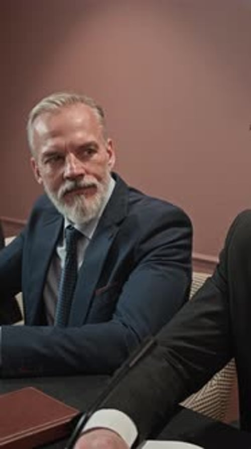 Une équipe de gens d'affaires d'âge mûr négocie à une table pendant la conférence
