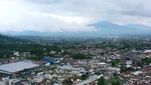 mountains and Bandung residential skyline on a cloudy day in Indonesia, aerial