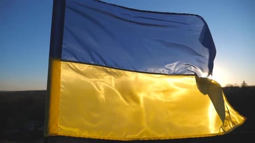 Ukrainian Flag Waving in Wind at Sunrise