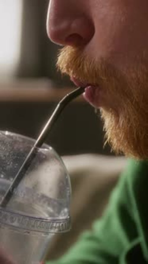 Close-up of Unrecognizable Man with Red Beard Sipping Soda