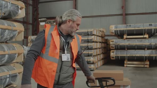 Warehouse Worker Pulling Pallet Jack with Boxes