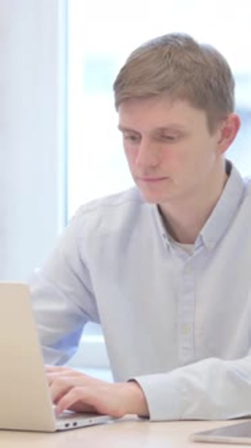 Young Businessman Typing on Laptop in Office, vertical video