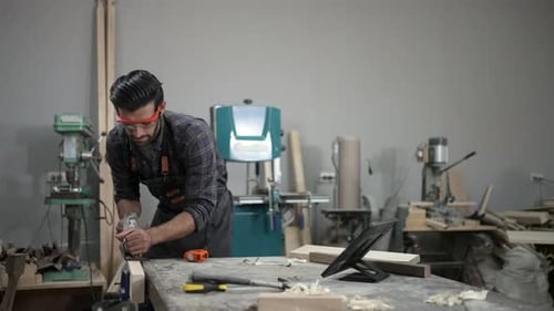 Carpenter is working at workshop.