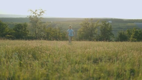 Happy Child Jumps and Runs Forward in Field Freedom in Motion