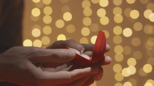 Closeup of Hands Opening a Red Box for Wedding Ring and Jewelry