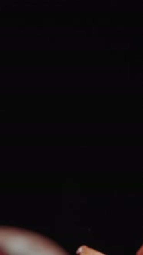 Vertical video. Movement from the top down, emerging from darkness.