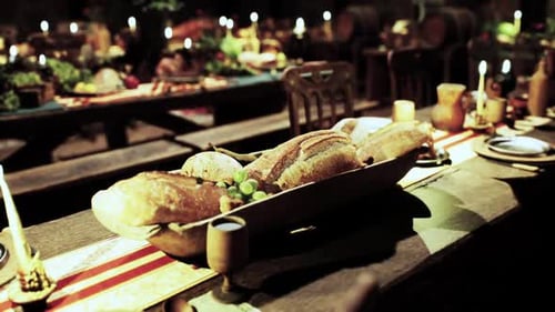 Warm Medieval Banquet Table with Bread and Candles Panning Shot