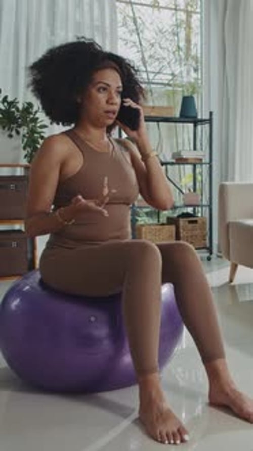 Woman Talking on Phone While Sitting on Exercise Ball