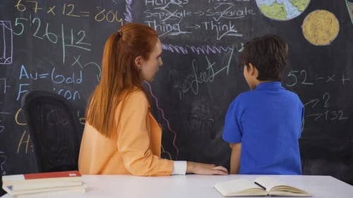 Teacher Tutoring a Student in Classroom Setting