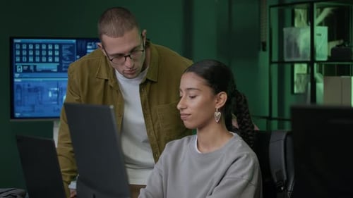 Junge, vielfältige Programmierer diskutieren während des Unterrichtsprozesses über ihre Arbeit