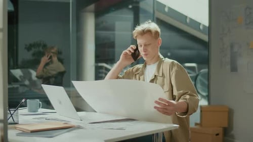 Focused Young Man in Bright Office Talkng About the Project with Partners