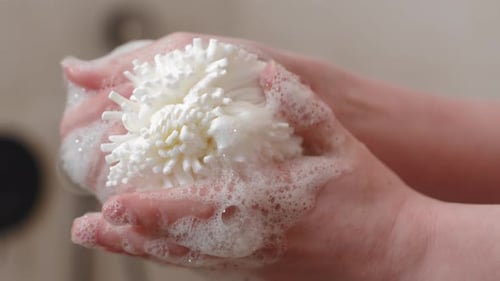 Shower Exfoliate Bath Sponge In The Hands Of A Woman. Close-Up Shot