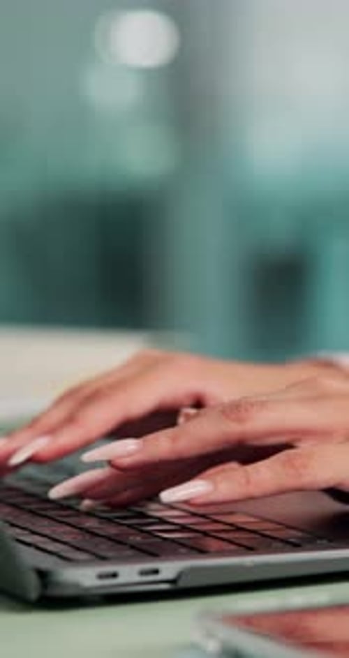 Hands Typing on Laptop in Modern Office