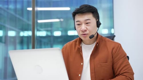 Professional Man Uses Headset Speaking into Computer